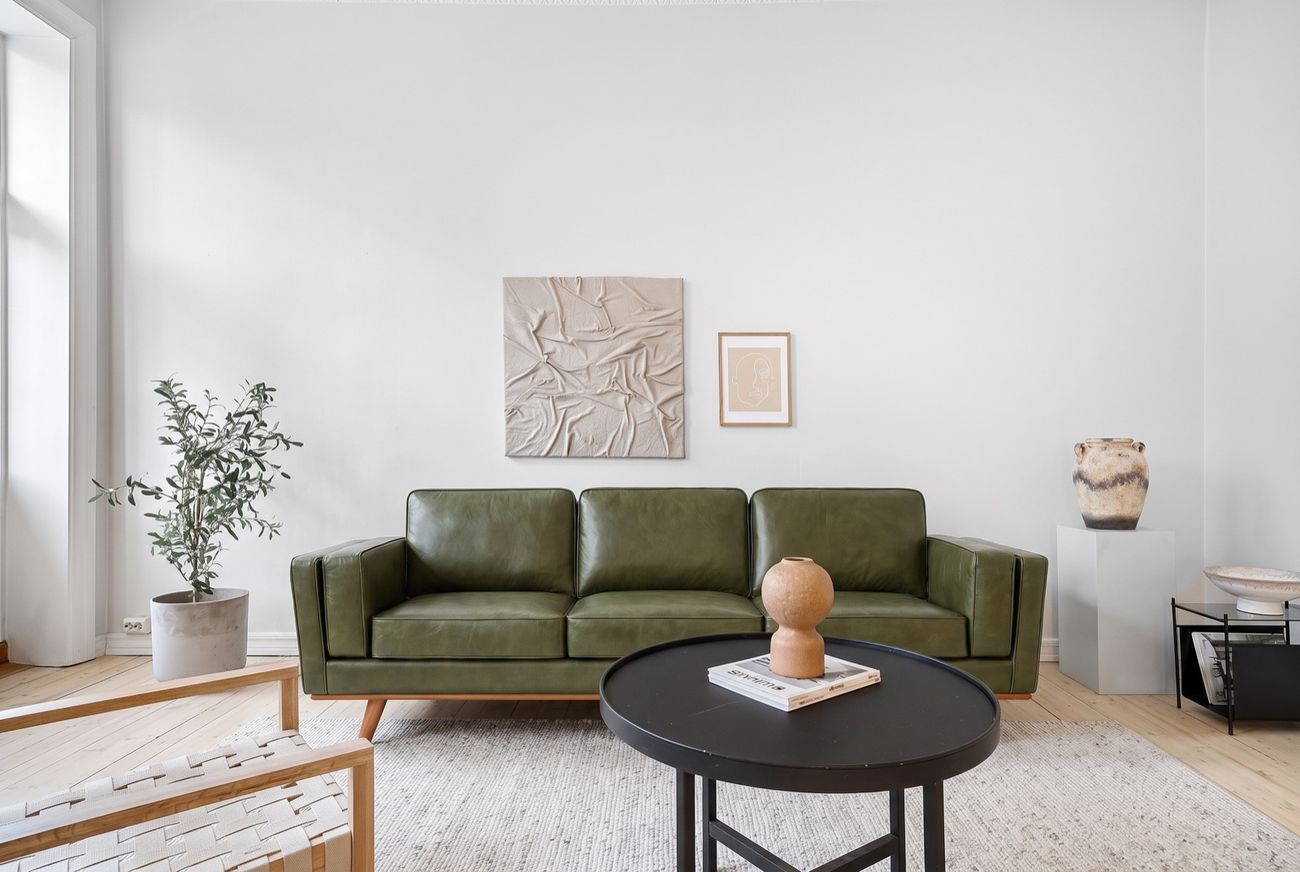 The same living room with an olive vegan leather sofa placed in it